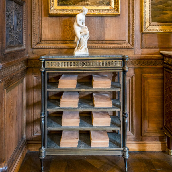 Console étagère - Louis XVI Console étagère étroite en ébène, ornée de bronzes ciselés et dorés, ouvrant par un tiroir et présentant quatre tablettes en marbre bleu turquin.